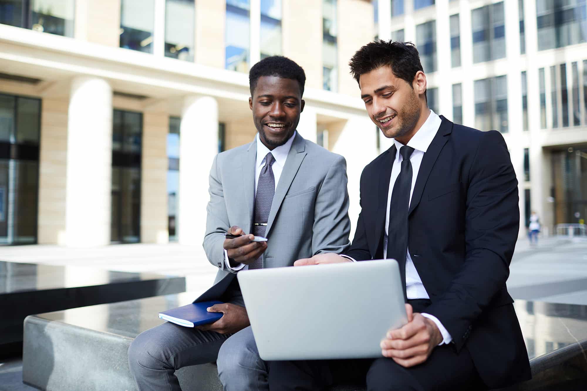 Two business men with a laptop talking